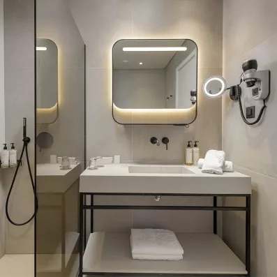 salle de bain avec douche italienne et vasque en blanc  et miroir accroché 
