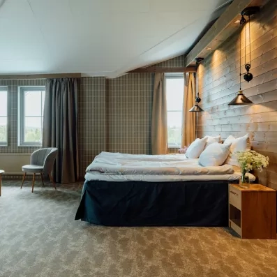 Chambre spacieuse de l'Hôtel Matarengi Lodge avec design boisé, idéale pour un séjour confort en Laponie.