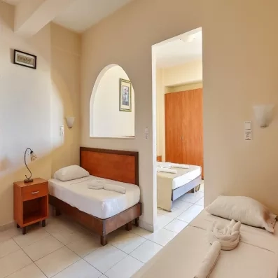 chambre double avec lit deux places et 2 lits d'appoint, une armoire en bois, porte fenêtre de la terrasse 