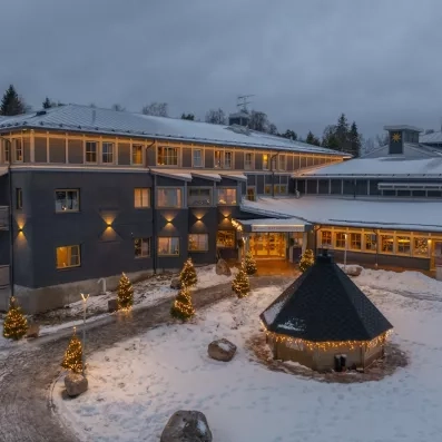 Façade illuminée de l'Hôtel Matarengi Lodge sous la neige, ambiance magique pour un voyage en Laponie.