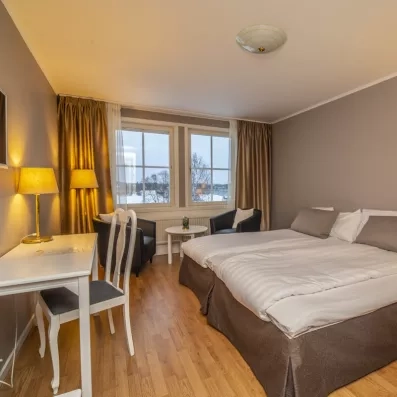 Chambre double spacieuse avec vue sur la nature hivernale, séjour authentique au Grand Arctic Resort, Laponie.