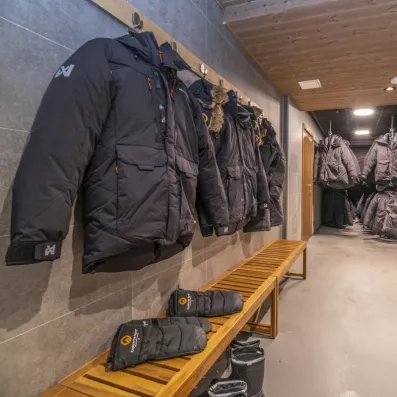 Vestiaire de l'Hôtel Matarengi Lodge avec parkas grand froid et bottes, équipement inclus pour votre aventure polaire.