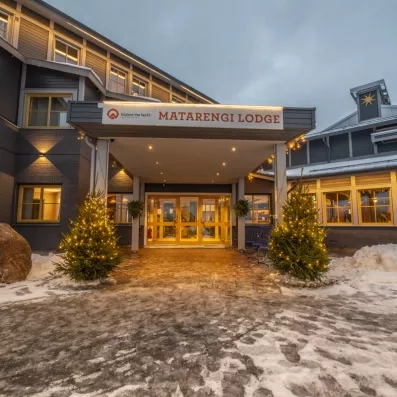Entrée principale illuminée du Matarengi Lodge avec sapins de Noël, bienvenue féerique pour votre séjour d'hiver.