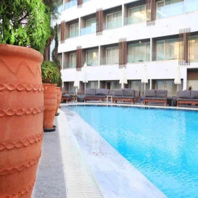 piscine extérieur de l'hôtel, transats, parasols, bâtiment de l'hôtel , bac à plantes
