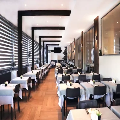 Restaurant principal de l'hôtel avec chaises et tables bien dressés 