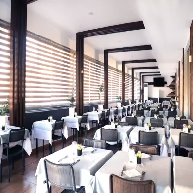 Restaurant principal de l'hôtel avec chaises et tables bien dressés 