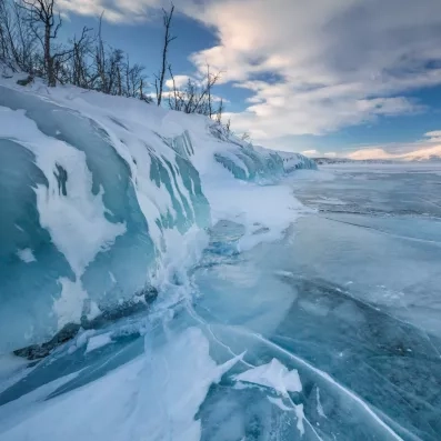Formations de glace bleue au bord d'un lac gelé, merveille naturelle d'un voyage en Laponie.