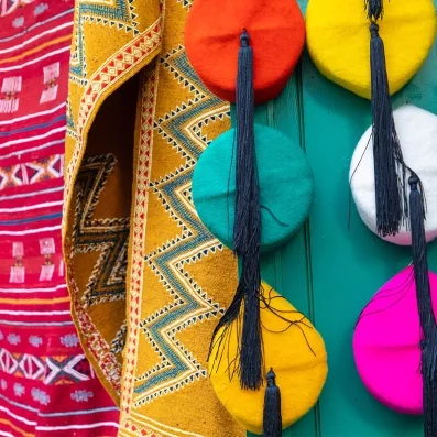 Souks de Monastir, étals colorés montrant des chapeaux typiques, artisanat local et ambiance typique des marchés tunisiens