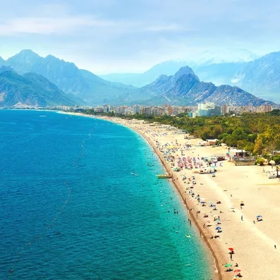 Vue d’Antalya sur la Riviera turque, plages de galets, eaux turquoise et montagnes du Taurus en arrière‑plan.