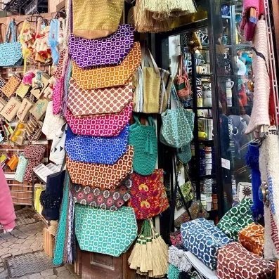 Allée des souks de Marrakech avec tapis, babouches et objets artisanaux, immersion dans la culture et le commerce local.