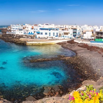 Maisons blanches d’El Cotillo à Fuerteventura, village de pêcheurs en bord de mer, eau turquoise et côte volcanique.