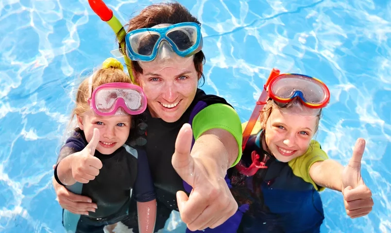 Famille faisant du snorkeling en mer Rouge, masques et tubas, activité ludique avec enfants dans les eaux turquoise d’Égypte.