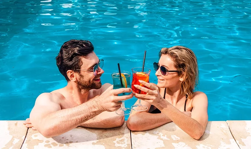 Couple dégustant un cocktail dans une piscine