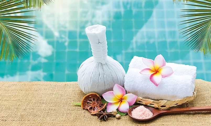 Serviette et fleur au bord d'un piscine