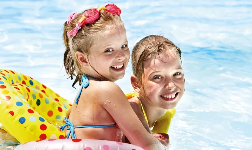 2 enfants jouant dans une piscine avec des bouées colorées