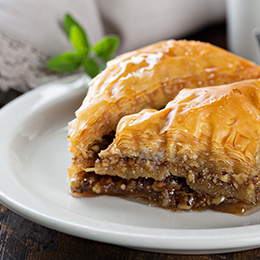Baklavas crétois doré au miel, dessert traditionnel grec à base de pâte filo et fruits secs, servi en gros plan gourmand.