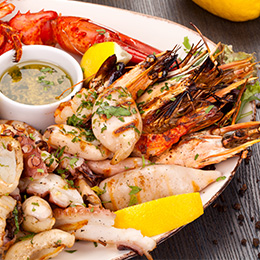 Plateau de fruits de mer frais en Crète : crevettes, calamars et homard grillés, cuisine méditerranéenne aux saveurs iodées.