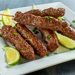 Koftas égyptiennes grillées, brochettes de viande hachée aux épices servies avec citron, spécialité populaire.