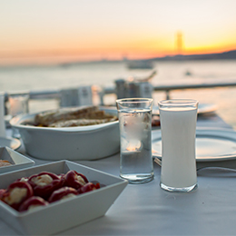 Verre de raki turc en terrasse face à la mer, boisson anisée traditionnelle accompagnant les mezzés en Turquie.
